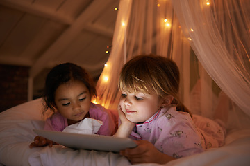 Image showing Girls, bedroom and tablet for a movie, night and relax with pajamas, chilling and games at home. Female children, young people and kids with technology, bed or bonding with fun, playful and happiness
