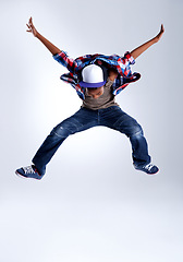 Image showing Talent, jump and child hip hop dancer dancing isolated in a white studio background in a pose feeling excited. Dance, jumping and boy kid with energy and skill ready for breakdance performance