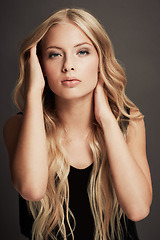 Image showing Hair, beauty and face portrait of a woman with makeup, cosmetics and shine in studio. Headshot of a female aesthetic model with a skin glow, luxury haircare or hairdresser style on a grey background