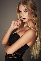 Image showing Face, beauty and portrait of a seductive woman in studio with makeup, cosmetics and long hair. Headshot of female aesthetic model with natural glow, luxury skincare and sexy pose on a grey background