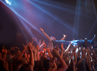 Image showing Crowd surfing, lighting and people at rock concert or music festival, neon lights and energy at live event. Dance, fun and group of excited fans in arena at rock show performance, audience stage dive