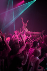 Image showing Crowd surf, neon and people at music festival with neon pink lighting and energy at live concert event. Dance, fun and group of excited gen z fans in arena at rock band performance or audience party.