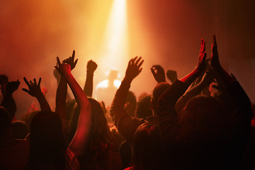 Image showing Hands of people in crowd dancing at concert or music festival, neon lights and energy at live event. Dance, applause and group of excited fans in silhouette at rock band performance with lighting.