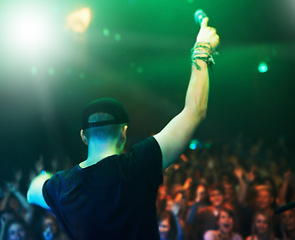 Image showing Music, rock and stage with man and microphone singing for concert, festival and party event. Light, celebration and performance with singer and band at nightclub for disco, techno or new year show