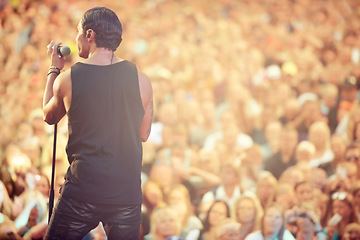 Image showing Singer, microphone and concert with man at festival for rock, performance and party in nature. Celebration, energy and audience with male musician on stage for club, rave and show event in outdoors