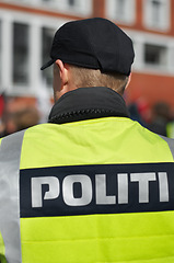 Image showing Law enforcement, protection and security with back of police officer in city for peace, safety or rally. Emergency services, justice and guard with person in Denmark street for help, order and arrest