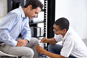 Image showing Server room, it support and hardware with a technician showing a cable comparison to a business man. Network, database and consulting with an engineer chatting about wire maintenance or management