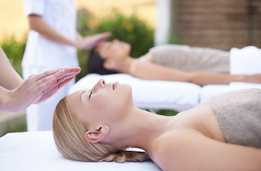 Image showing Reiki, facial flow and women at spa for health, wellness and chakra energy healing with luxury stress relief treatment. Beauty salon, skin care and woman in holistic massage on face for calm aura.