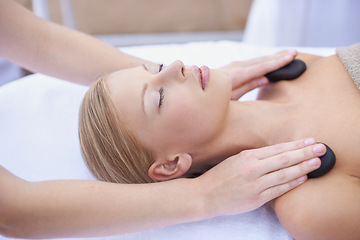 Image showing Woman getting hot stone massage, hands of masseuse in spa and healing holistic treatment with zen at wellness resort. Rocks on shoulders, peace with therapy, alternative medicine and self care