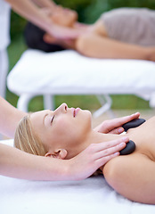 Image showing Woman, zen and hot stone massage with hands of masseuse at spa, healing with holistic treatment. Rocks on shoulders, peace with therapy at wellness luxury resort, alternative medicine and self care