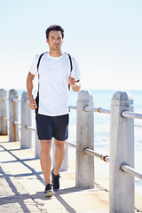 Image showing Man, fitness and running by the beach for exercise, workout or training in the nature outdoors. Fit, active or athletic male runner exercising on the ocean coast for run, healthy cardio and wellness