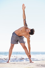 Image showing Fitness, man and stretching body on beach for exercise, yoga or getting ready for workout or training in nature. Fit, active or muscular male yogi in warm up stretch, cardio or exercising by an ocean