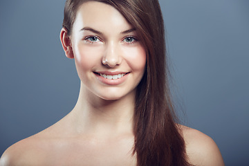 Image showing Face, skin and beauty portrait of a woman in studio with natural makeup, smile and cosmetics. Happy aesthetic gen z female model on a grey background for glow, hair care and facial dermatology shine