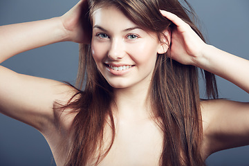 Image showing Beauty, face and smile portrait of a woman in studio with hands in hair care, makeup and cosmetics. Headshot of happy young female model on a grey background for natural glow, skincare or dermatology