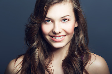 Image showing Beauty, natural and portrait of happy woman in studio with makeup, facial and skincare routine. Health, smile and face of young female model with cosmetic or dermatology treatment by blue background.