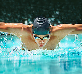Image showing Water splash, sport and training with man in swimming pool for competition, workout and energy. Strong, fitness and cardio with male swimmer and practice for athlete, championship and race at gala