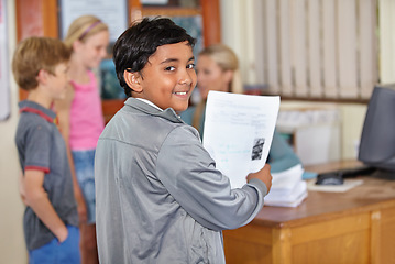 Image showing Portrait, child and smile of student with paper in classroom for assignment or class test. Happiness, education and Indian kid with document for studying, learning and assessment in primary school.