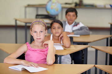 Image showing Portrait, serious kids and student in classroom with book, ready to learn and study in class. Group of students, education and girl learning in primary school for knowledge, development or studying.