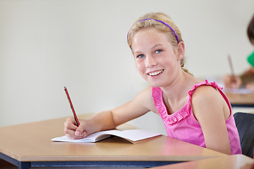 Image showing Portrait, child and smile of student learning in classroom for knowledge, education or development. Happy, girl and learner writing in notebook, studying or taking notes in middle school in Canada.