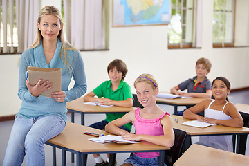 Image showing Portrait, teacher and woman with students in classroom, smile and holding folder. Happiness, female educator and group of children ready for learning, education or teaching in elementary school class