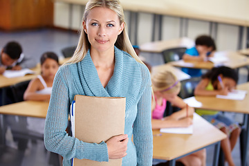 Image showing Teacher, portrait and woman with binder in classroom, elementary school or class. Education, teaching and female educator with folder, paperwork or documents for serious learning, knowledge or study.