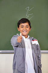 Image showing Portrait, child and thumbs up of student on chalkboard in classroom, elementary school and mockup. Blackboard, education and kid with hand gesture for like emoji, agreement and learning with a smile.