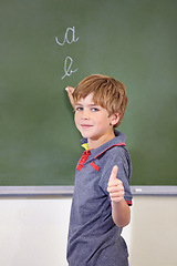 Image showing Portrait, child and student with thumbs up on blackboard in classroom, elementary school and mockup. Chalkboard, education and kid with hand gesture for like emoji, agreement and learning to write.