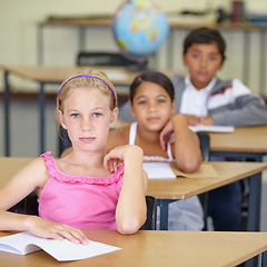 Image showing Portrait, serious child and student in classroom with book, ready to learn and study in class. Group of students, education and girl learning in primary school for knowledge, development or studying.