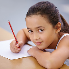 Image showing Child, portrait and education of student taking notes in classroom for knowledge and development. Serious, girl and learner writing on paper, studying or learning in middle school class in Spain.