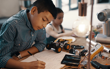 Image showing Learning, writing in notebook and child with robotics homework, homeschool and science for tech project. Taking notes, car robot and boy kid with knowledge, education and studying in house alone.