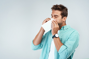 Image showing Allergy, sick and man blowing nose in tissue with flu, illness and virus on studio background. Health mockup, wellness and face of male person with handkerchief for hayfever sinus, cold and sneeze