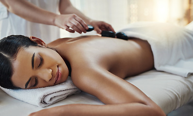 Image showing Woman, hands and sleeping for rock massage, skincare or relaxation on bed at indoor beauty spa. Hand of masseuse applying hot rocks to female in relax for physical therapy or back treatment at resort