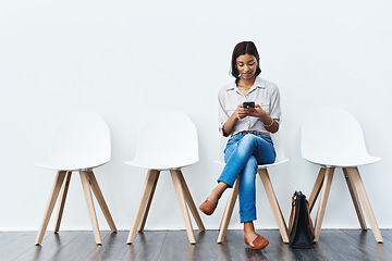 Image showing Phone, social media and woman in interview waiting room and search the internet, web or website sitting on chairs. Internship, mockup and young female person texting online ready for a new job