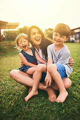 Image showing Mother, happy kids or hug playing on grass for fun bonding in summer outside a house in nature. Funny mom hugging playful children on garden playground outdoors with happiness of family together