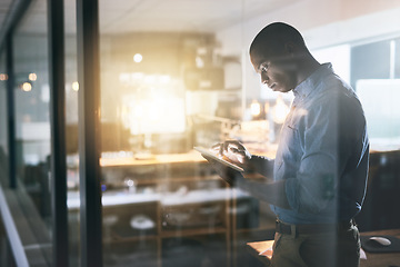 Image showing Black man in business, tablet and night at office, information technology and software update. Male programmer work late, overtime and deadline with focus, concentration and cyber security upgrade