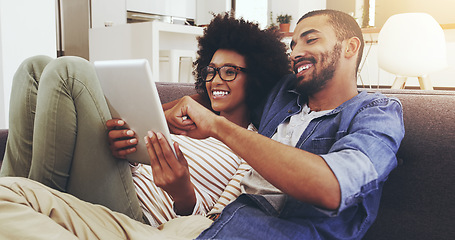 Image showing Happy, home and couple on a couch, tablet and bonding with romance, typing and watching a film. Partners, man and woman on a sofa, technology and conversation with movie, network and internet search