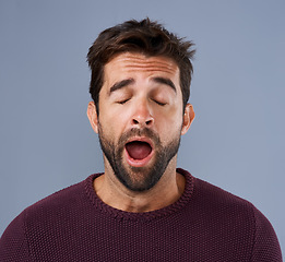 Image showing Tired, yawn and man in studio for fatigue or low energy against a grey background. Exhausted, yawning and face of bored male sleepy, lazy or suffering from insomnia, problem or burnout with emoji