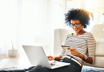 Image showing Young woman, laptop and credit card while doing online shopping sitting on ground. Home, happiness and computer internet deal of African female person on an ecommerce app reading banking details