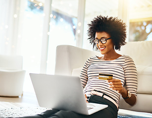 Image showing Young woman, laptop and credit card in living room doing online shopping sitting on ground. Home, happiness and computer of African female person on a internet ecommerce app reading online deal