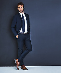 Image showing Portrait, fashion and a mockup with a business man in studio on a blue background for contemporary corporate style. Success, professional and a confident male employee in a suit for executive power