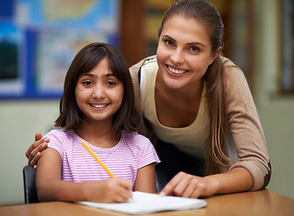 Image showing Portrait, education or school with a student and teacher in a classroom together for writing or child development. Study, learning and teaching with a woman educator helping a girl child in class