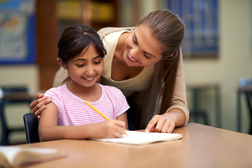 Image showing School, education or study with a student and teacher in a classroom together for writing or child development. Learning, scholarship and teaching with a woman educator helping a girl child in class