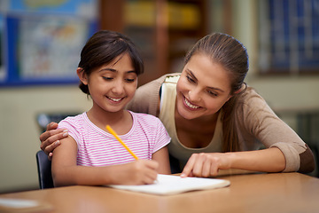 Image showing School, education or scholarship with a student and teacher in a classroom together for writing or child development. Study, learning and teaching with a woman educator helping a girl child in class