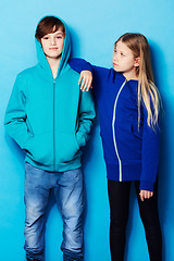 Image showing Fashion, portrait and teenager models in a studio with a casual, cool and stylish outfit. Youth, friendship and young boy and girl posing together with trendy apparel style by a blue background.