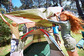 Image showing Happy children, portrait and tent setup in camping forest for shelter, cover or insurance together on the grass in nature. Kids in teamwork setting up tents for camp adventure or holiday in the woods