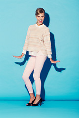 Image showing Portrait, happy and carefree with a woman in studio on a blue background for cheerful freedom. Fashion, smile and dance gesture with an attractive young female model having fun against a color wall