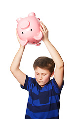 Image showing Piggy bank, smash and young boy in studio for finance, savings and decision against white background. Money box, breaking and preteen male person with investment, cash and future financial freedom