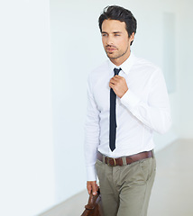 Image showing Thinking, corporate and tie with a business man in a modern white collar office at work. Idea, getting ready or career and a handsome young male employee walking into in his workplace with ambition