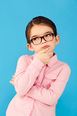 Image showing Thinking, ideas and girl with decision, choice and happiness against a blue studio background. Female child, kid and young person with glasses, thoughts and wonder with information, future and geek