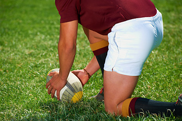 Image showing Hands, rugby and closeup of a man with a ball outdoor on a pitch for action, goal or start. Male athlete person playing in sport competition, game or training for fitness, workout or exercise to kick